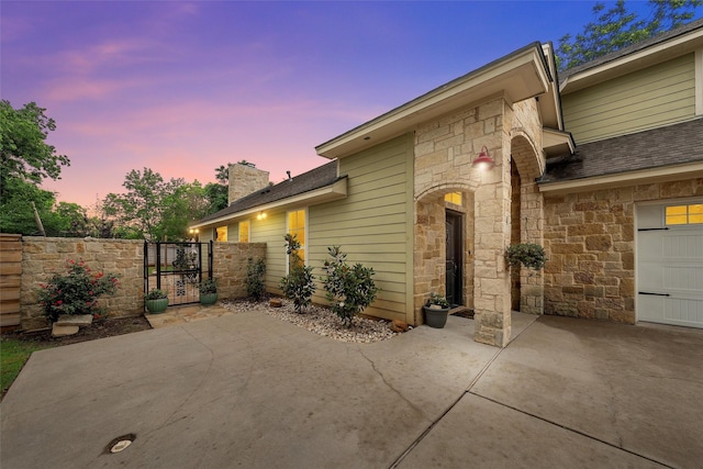 9359 W 5th St, Crawford, TX 76638 - patio terrace at dusk featuring a gate, driveway, and a patio