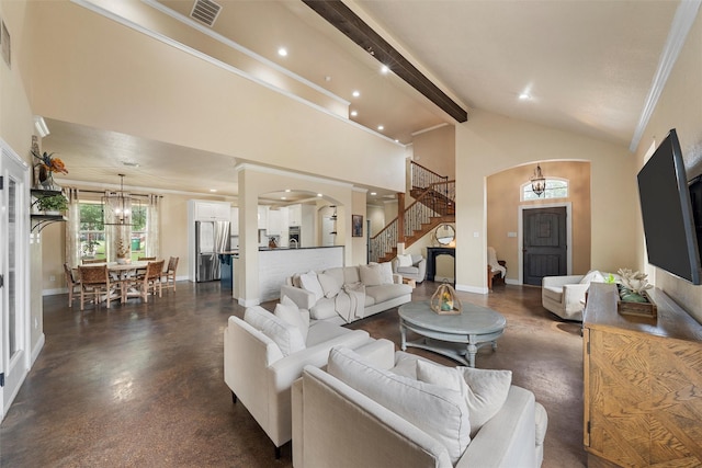 9359 W 5th St, Crawford, TX 76638 - living room with arched walkways, stairs, a chandelier, beam ceiling, and concrete floors