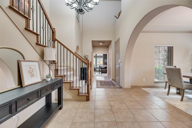 7704 Michael Ct, Mckinney, TX 75071 - entryway featuring arched walkways, a chandelier, light tile patterned flooring, stairs, and a high ceiling