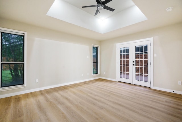 1202 Bayshore Dr, Rockwall, TX 75087 - unfurnished room with french doors, wood finished floors, a ceiling fan, and a tray ceiling