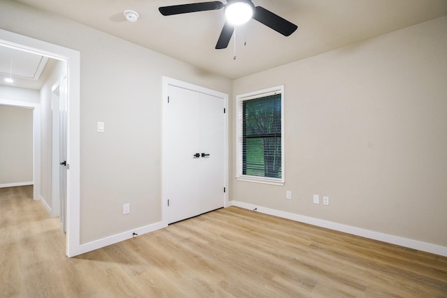1202 Bayshore Dr, Rockwall, TX 75087 - unfurnished bedroom featuring attic access, light wood-type flooring, baseboards, ceiling fan, and a closet