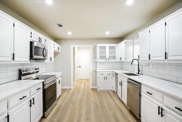 1202 Bayshore Dr, Rockwall, TX 75087 - kitchen featuring stainless steel appliances, a sink, recessed lighting, and white cabinetry
