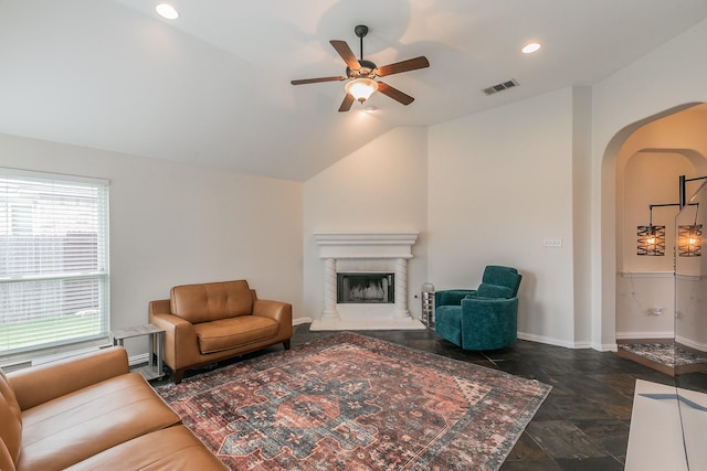941 Sequoia Way, Saginaw, TX 76131 - living area with arched walkways, a ceiling fan, a fireplace with raised hearth, vaulted ceiling, and dark stone finish flooring