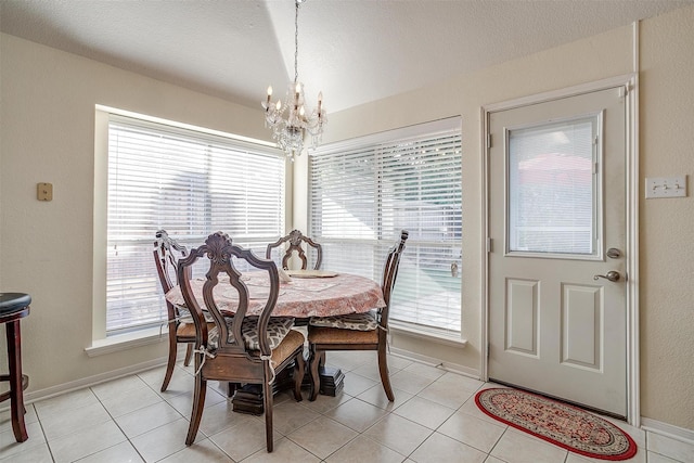 dining space with a chandelier, healthy amount of natural light, light tile patterned floors, and baseboards