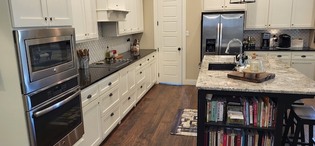 413 Prairie Crk, Sulphur Springs, TX 75482 - kitchen featuring appliances with stainless steel finishes, decorative backsplash, a sink, and white cabinetry