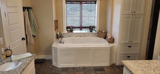 413 Prairie Crk, Sulphur Springs, TX 75482 - bathroom featuring a garden tub, baseboards, vanity, and stone finish flooring