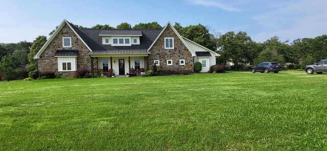 413 Prairie Crk, Sulphur Springs, TX 75482 - view of front facade featuring stone siding, a front lawn, a standing seam roof, covered porch, and metal roof