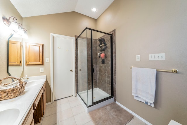 5704 Poole Dr, The Colony, TX 75056 - full bathroom with double vanity, a stall shower, tile patterned floors, vaulted ceiling, and baseboards