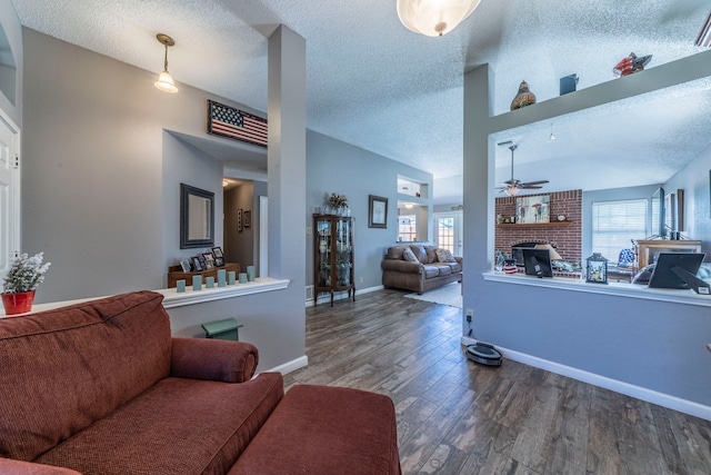 5704 Poole Dr, The Colony, TX 75056 - living area featuring a ceiling fan, wood finished floors, a fireplace, a textured ceiling, and baseboards
