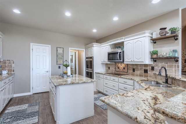 1777 Lone Star Blvd, Terrell, TX 75160 - kitchen with appliances with stainless steel finishes, open shelves, a sink, light stone countertops, and a kitchen island