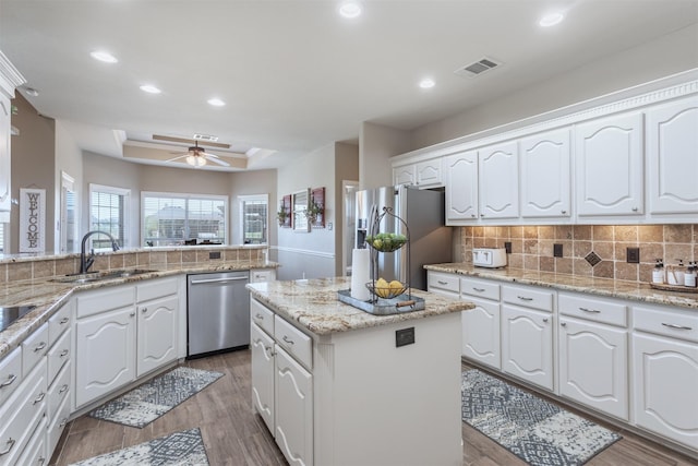 1777 Lone Star Blvd, Terrell, TX 75160 - kitchen featuring appliances with stainless steel finishes, a sink, a raised ceiling, a center island, and recessed lighting