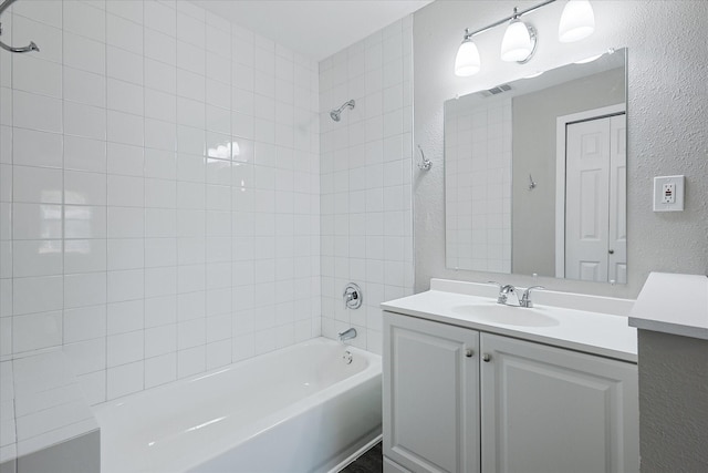 821 Collin Dr, Euless, TX 76039 - bathroom with a textured wall, shower / bathtub combination, and vanity