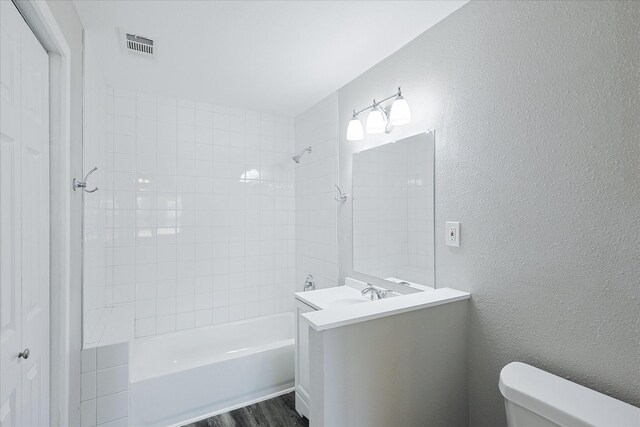821 Collin Dr, Euless, TX 76039 - full bath with toilet, a textured wall, shower / bath combination, vanity, and wood finished floors