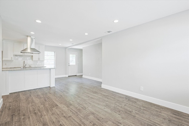 821 Collin Dr, Euless, TX 76039 - unfurnished living room featuring baseboards, recessed lighting, light wood-style floors, and a sink