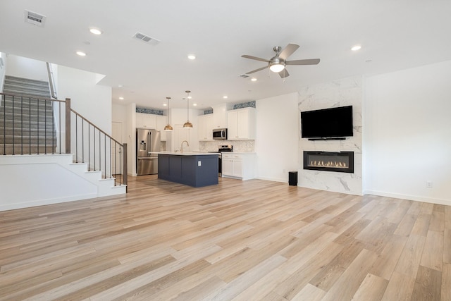 913 Emerling Dr, Mckinney, TX 75069 - unfurnished living room with a sink, ceiling fan, stairs, light wood-style flooring, and recessed lighting