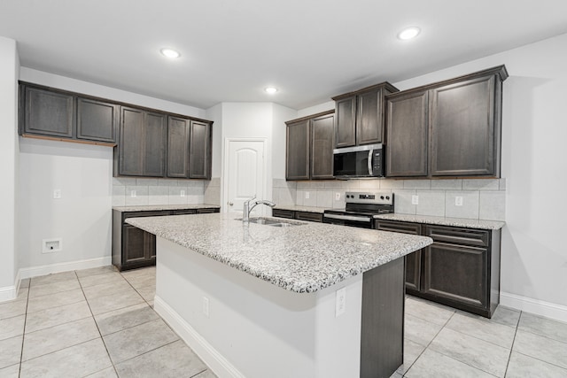 1211 Templin Ave, Forney, TX 75126 - kitchen with stainless steel appliances, a sink, dark brown cabinets, tasteful backsplash, and light stone countertops