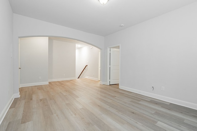 1211 Templin Ave, Forney, TX 75126 - spare room featuring light wood finished floors, arched walkways, and baseboards