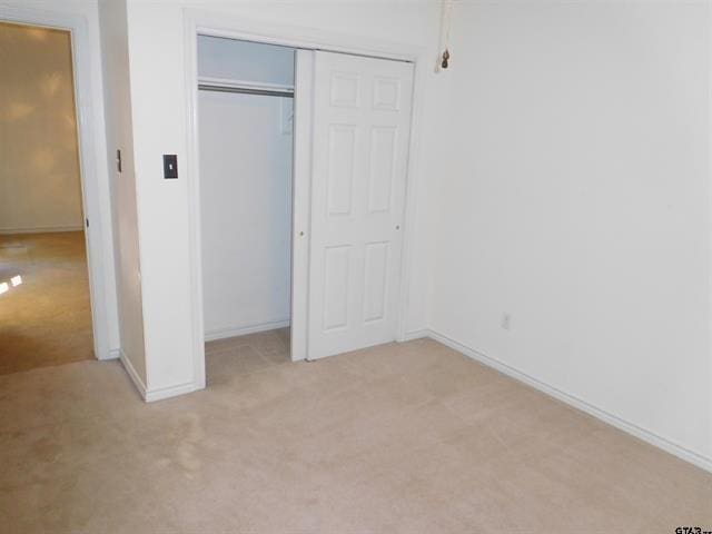 405 Cherry St, Chandler, TX 75758 - unfurnished bedroom with light colored carpet, a closet, and baseboards