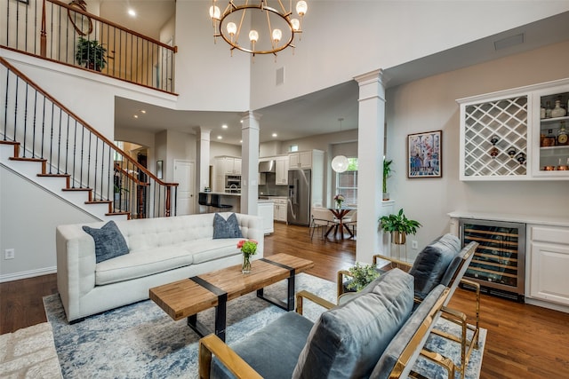 5001 Stanford Ave, Dallas, TX 75209 - living area with beverage cooler, ornate columns, stairway, dark wood finished floors, and a towering ceiling