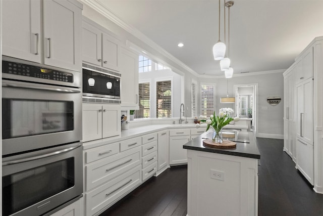 2906 Cottonwood Ln, Colleyville, TX 76034 - kitchen with appliances with stainless steel finishes, crown molding, a center island, a sink, and white cabinets