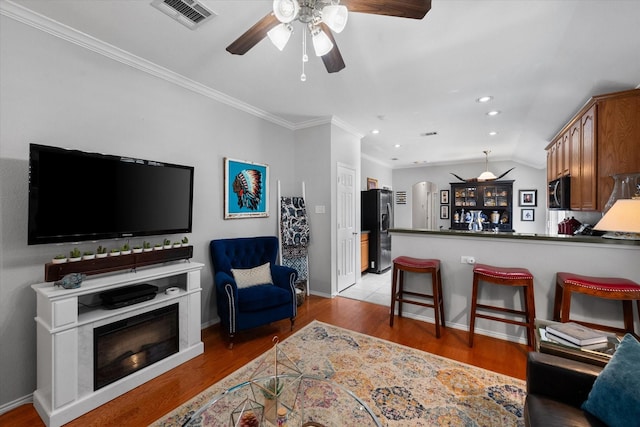 2411 Ravenwood Ct, Mansfield, TX 76063 - living room with ceiling fan, recessed lighting, baseboards, light wood-type flooring, and crown molding