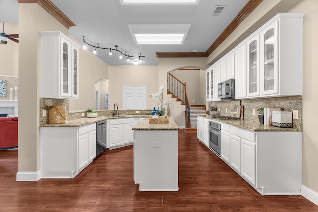 9772 Hickory St, Frisco, TX 75035 - kitchen with stainless steel appliances, arched walkways, a peninsula, decorative backsplash, and ornamental molding