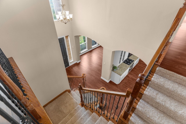 9772 Hickory St, Frisco, TX 75035 - stairway featuring arched walkways, baseboards, a chandelier, and a high ceiling