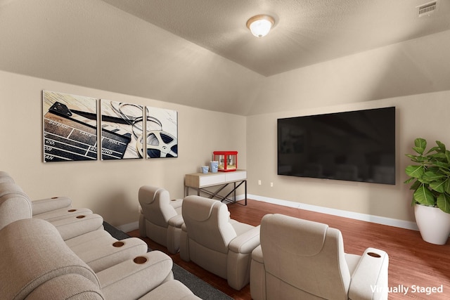 9772 Hickory St, Frisco, TX 75035 - home theater room featuring wood finished floors, baseboards, and vaulted ceiling