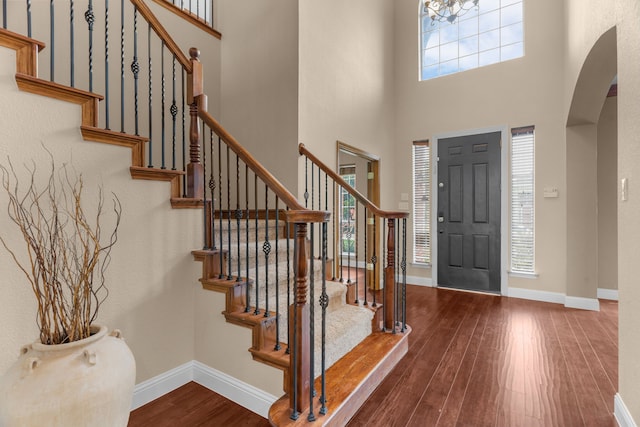 9772 Hickory St, Frisco, TX 75035 - foyer entrance with arched walkways, hardwood / wood-style flooring, stairs, a towering ceiling, and baseboards