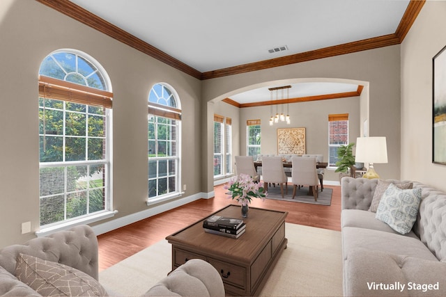 9772 Hickory St, Frisco, TX 75035 - living area with plenty of natural light, ornamental molding, arched walkways, and wood finished floors