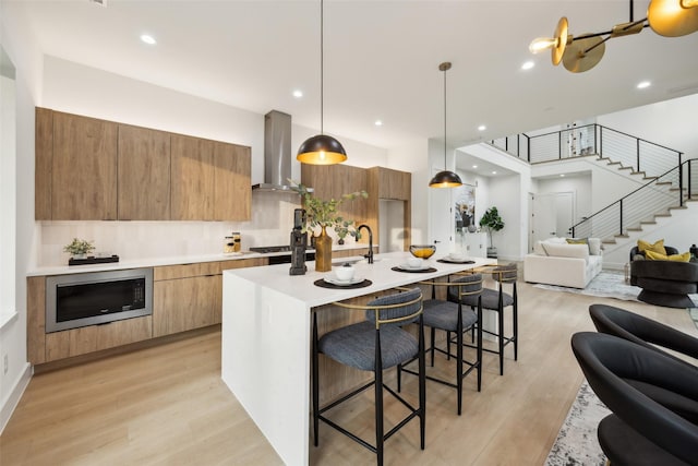 5217 Lindsley Ave, Dallas, TX 75223 - kitchen featuring wall chimney exhaust hood, modern cabinets, open floor plan, built in microwave, and recessed lighting