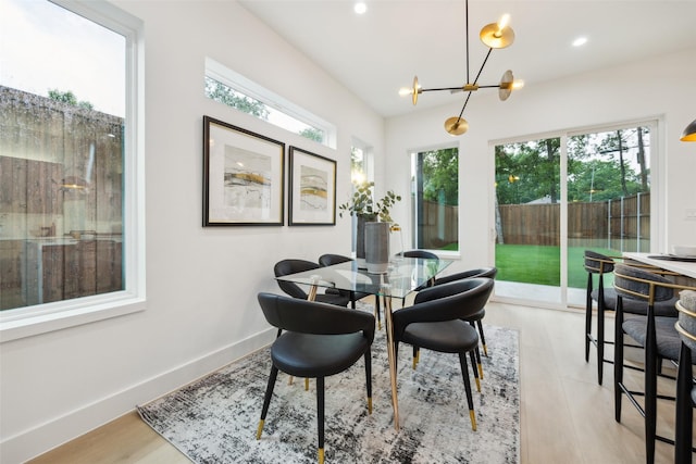 5217 Lindsley Ave, Dallas, TX 75223 - dining room with healthy amount of natural light, a chandelier, recessed lighting, wood finished floors, and baseboards