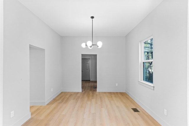 511 W Munson St, Denison, TX 75020 - spare room with light wood finished floors, a chandelier, and baseboards