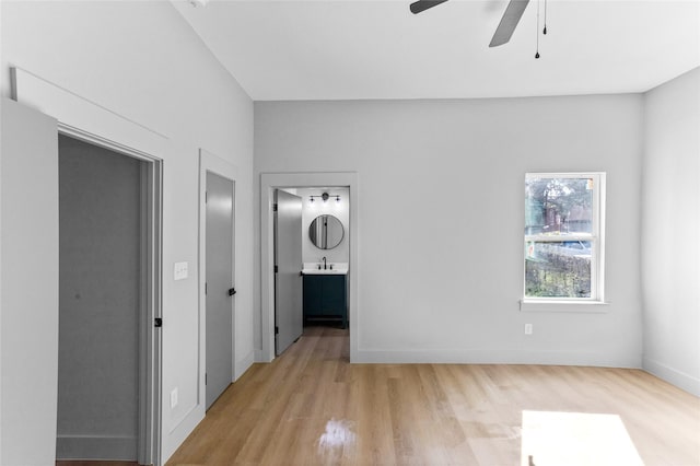 511 W Munson St, Denison, TX 75020 - unfurnished bedroom with light wood-type flooring, a sink, baseboards, connected bathroom, and a ceiling fan