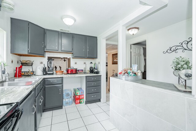 350 Vz County Road 3907, Wills Point, TX 75169 - kitchen with gray cabinetry, electric stove, a sink, light tile patterned flooring, and crown molding