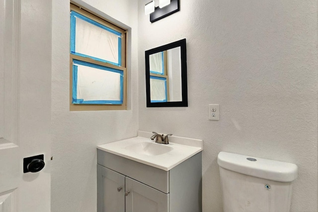 3920 Vanette Ln, Dallas, TX 75216 - bathroom with vanity, toilet, and a textured wall