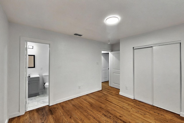 3920 Vanette Ln, Dallas, TX 75216 - unfurnished bedroom featuring ensuite bath, a closet, and baseboards