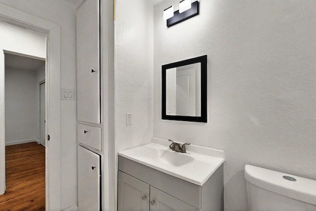 3920 Vanette Ln, Dallas, TX 75216 - half bath with toilet, wood finished floors, and vanity