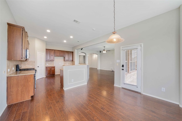 5125 Sugarberry Dr, Mckinney, TX 75071 - kitchen featuring stainless steel appliances, a ceiling fan, brown cabinetry, backsplash, and dark wood finished floors