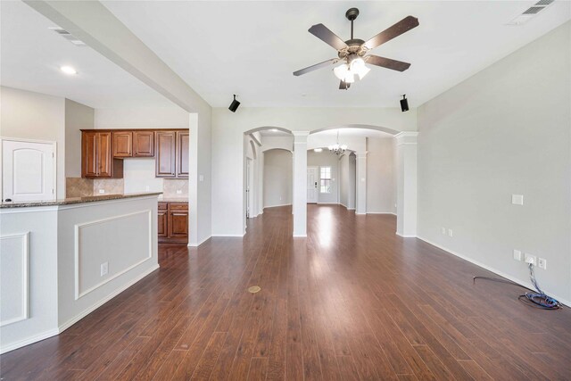 5125 Sugarberry Dr, Mckinney, TX 75071 - unfurnished living room featuring decorative columns, arched walkways, ceiling fan, and dark wood finished floors