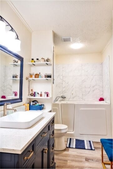 324 Peachtree St, Fairfield, TX 75840 - bathroom with wood finished floors, ornamental molding, vanity, a bath, and toilet