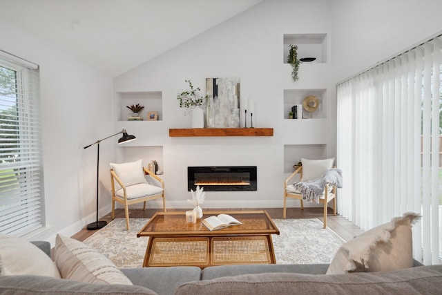 2123 Wheaton Dr, Richardson, TX 75081 - living area with a glass covered fireplace, wood finished floors, baseboards, high vaulted ceiling, and built in features