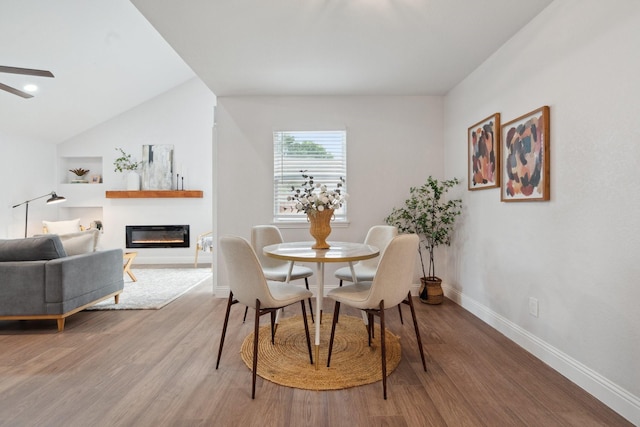 2123 Wheaton Dr, Richardson, TX 75081 - dining room featuring a glass covered fireplace, baseboards, wood finished floors, and a ceiling fan