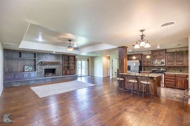 5626 Meadow Dr, Abilene, TX 79606 - kitchen featuring stainless steel appliances, a kitchen breakfast bar, dark wood-style floors, hanging light fixtures, and a ceiling fan