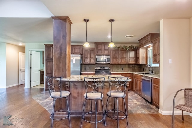 5626 Meadow Dr, Abilene, TX 79606 - kitchen featuring appliances with stainless steel finishes, a sink, baseboards, decorative backsplash, and light stone counters