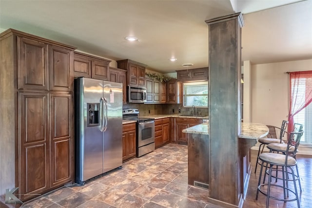 5626 Meadow Dr, Abilene, TX 79606 - kitchen featuring appliances with stainless steel finishes, a sink, plenty of natural light, light stone counters, and recessed lighting