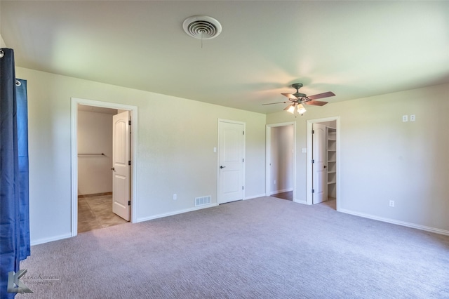 5626 Meadow Dr, Abilene, TX 79606 - unfurnished bedroom with a walk in closet, carpet flooring, baseboards, ceiling fan, and connected bathroom