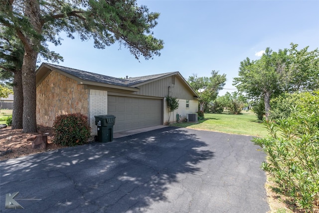 5626 Meadow Dr, Abilene, TX 79606 - view of home's exterior with asphalt driveway, a lawn, stone siding, an attached garage, and brick siding
