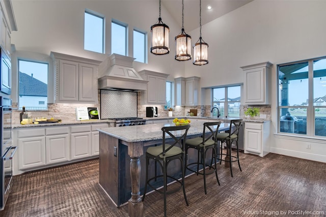 4604 Donna Ln, Parker, TX 75002 - kitchen featuring premium range hood, a center island, a chandelier, a towering ceiling, and range