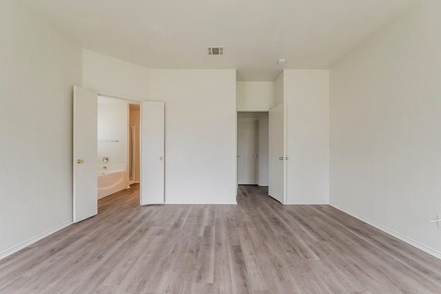 1720 Triumph Trl, Arlington, TX 76002 - unfurnished bedroom featuring light wood-type flooring, baseboards, and ensuite bath